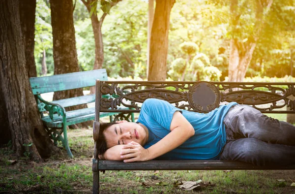 Alzheimer asian young man confusion or memory loss,male patient with dementia or homeless people sleeping on the bench in outdoor park,alzheimers disease,health care,social problem concept