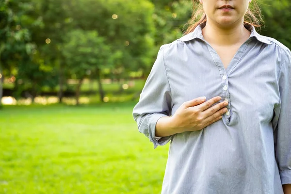 亚洲中年人检查乳房自检、女性乳腺癌检查、胸腔肿瘤症状、可能肿块、变形或肿胀、绿色自然背景的乳腺癌意识 — 图库照片