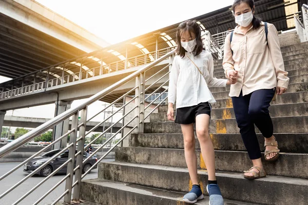 Denní rutina asijské dcery holčičky a matky trpí inhalací toxických výparů ve městě každý den, stává se každodenním životem, lidé nosí ochranu obličeje koncepce znečištění ovzduší, prachové alergie — Stock fotografie