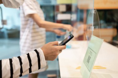 İnsanlar QR kod ödemelerini taramak için yüz maskesi takıyor ya da alışveriş merkezindeki mağazalara girmeden önce kayıt yaptırıyor, giriş çıkış yapıyor, çıkış yapıyor, kilit açıldıktan sonra hizmet veriyor.