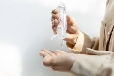 El dezenfektanını avuç içine sıkan ya da küçük taşınabilir plastik şişeden cilt bakım losyonunu döken bir kızın elleri, alkol antiseptik jeli, temizlik, sağlık ve güvenlik ile elini yıkayan kadın.