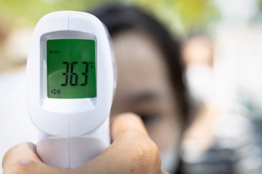 Kızıl ötesi dijital alın termometresini kapat, humma testi, önleme önlemleri, COVID-19 Coronavirus Kilitlemesi 'nden sonra vücut sıcaklığını kontrol eden insanlar,