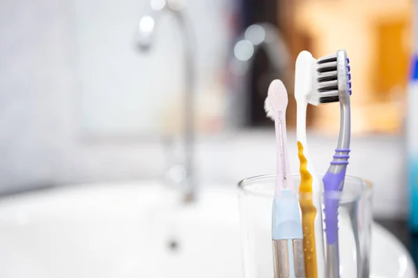 Toothbrushes are kept close together in the glasses,avoid keeping toothbrush heads close together,separate to safety,prevent the spread of COVID-19,pandemic of Coronavirus disease,new normal concept