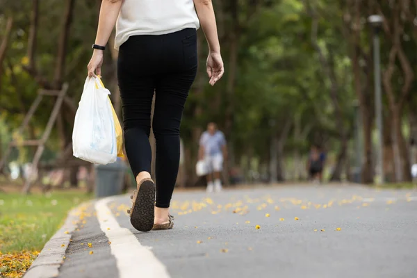 リサイクルの概念は 廃棄物の量を減らす アジアの女性は 再利用のための前のショッピングセッションで使用されるビニール袋を運ぶ 女性は路上で歩いていると食料品とビニール袋を保持 — ストック写真