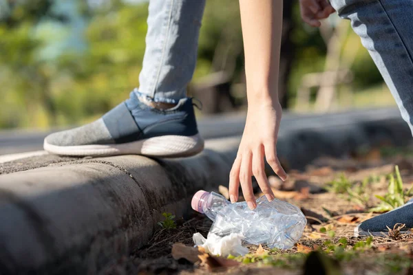 Asyalılar çöp topluyor, halka açık yerlerde çöp topluyor, çocuk parktaki plastik şişe çöplerini toplamak için eğiliyor, gönüllü toplum hizmeti yapıyor, dünyayı ve çevre kavramını kurtarıyor.