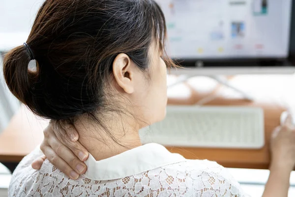 Tired asian woman with back neck and shoulders pain on muscle,stiff neck,symptom sore,painful while working,sick people have tension and injury in her scruff,office worker holding her nape of the neck