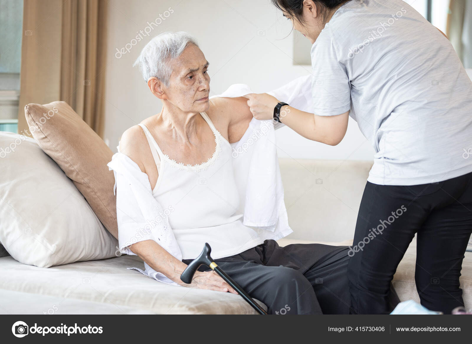 Asian Female Caregiver Taking Care Helping Elderly Patient Get Dressed