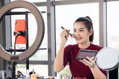 Güzel Asyalı etkileyiciler çeşitli kozmetik ürünlerini gözden geçirirler. Kadın güzellik blogcusu her gün kullandığı makyajını anlatıyor..