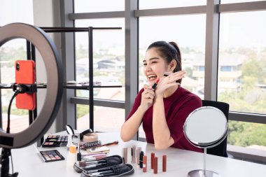 Güzel Asyalı etkileyiciler çeşitli kozmetik ürünlerini gözden geçirirler. Kadın güzellik blogcusu her gün kullandığı makyajını anlatıyor..