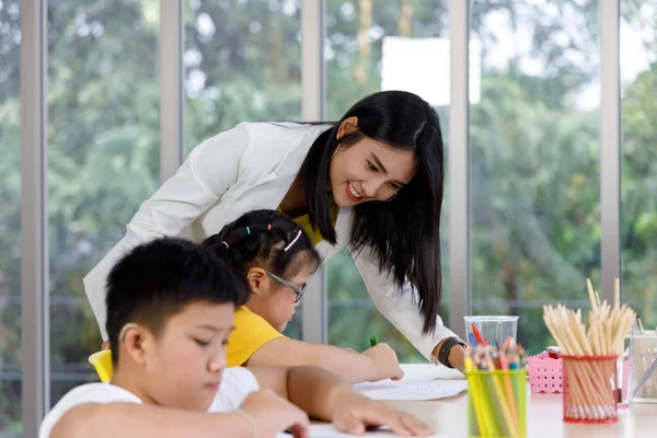 Asian woman teacher teaching art in classroom. Concept children learning at school.