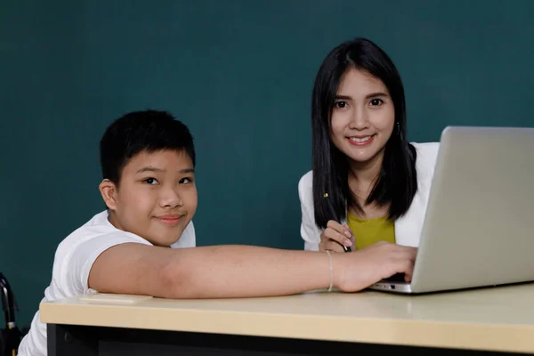 教室で先生とノートパソコンを使ってアジアの少年研究 — ストック写真