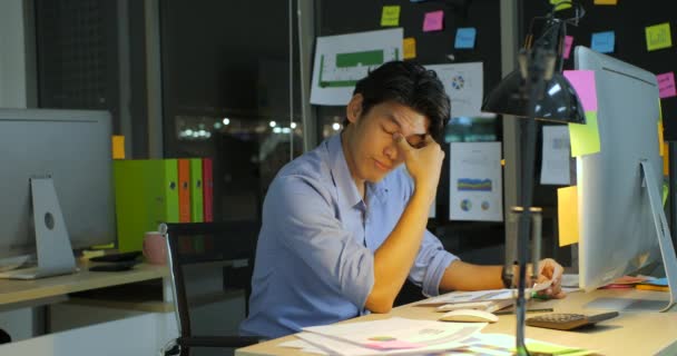 Καταπονημένος επιχειρηματίας που εργάζεται αργά τη νύχτα στο γραφείο. — Αρχείο Βίντεο