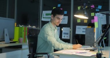 Gece geç saatte ofiste çalışan overworked işadamı.