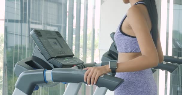 Asiática chica corriendo en la cinta de correr en el gimnasio . — Vídeo de stock