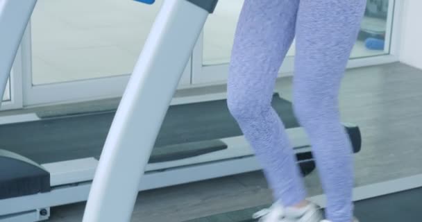 Asiatique fille courir sur le tapis roulant dans la salle de gym . — Video