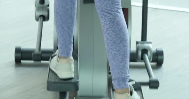 Asiatique fille exercice cardio sur la machine elliptique dans la salle de gym . — Video