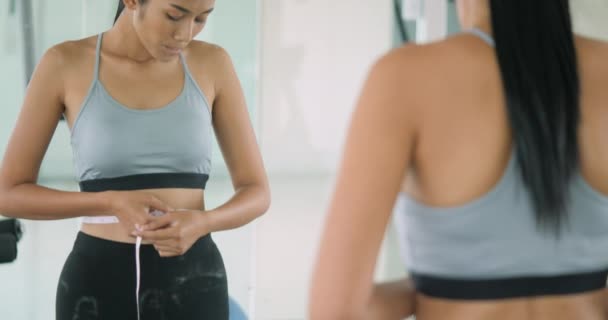 Mujer en el gimnasio luchando con su peso delante del espejo — Vídeos de Stock