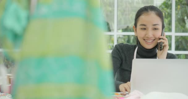 Projektant mody piękna kobieta siedzi przy biurku, rozmawiając przez telefon — Wideo stockowe