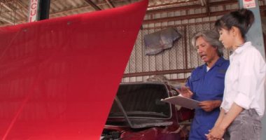 Garajda bir kadın müşteri konuşmaya makinist.