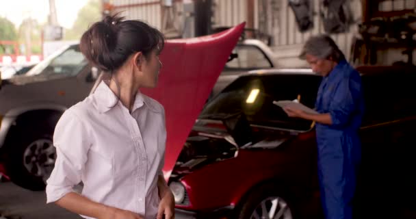 Retrato del cliente enojado mientras un mecánico trabaja en un coche en el fondo . — Vídeo de stock