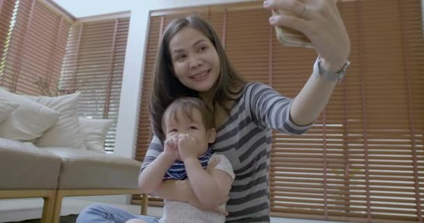 Happy mother taking selfie video with her son in living room — Stock Video