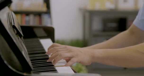 Ung asiatisk man spelar piano hemma — Stockvideo