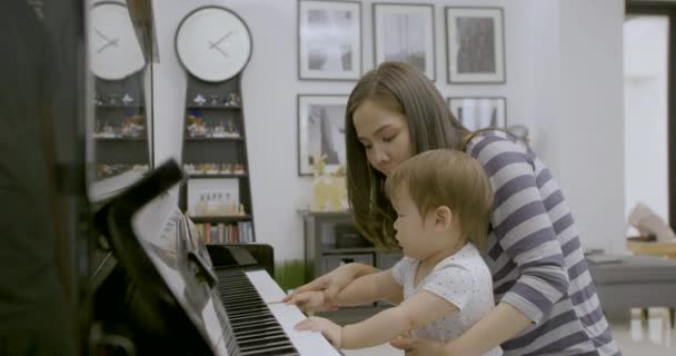 Jeune asiatique mère jouer du piano avec son bébé garçon . — Video