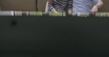 Genç Asyalı çift yeni evinde kanepede kucakladı televizyon seyretmek ve birlikte bir film izlemek.