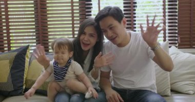 Mutlu aile kanepede oğulları ile oturan, birlikte iyi vakit geçiriyor ve Tv izlerken.