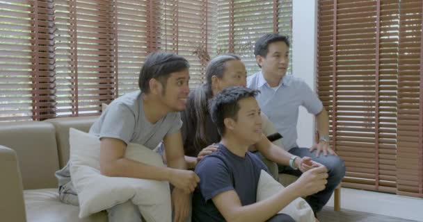 Group of asian flat mates watching sports competition on TV at home. — Stock Video