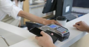 Güzel Asyalı kadın paket servisi olan restoran kahve parasını ödeyen bir müşteri tarafından temassız cep telefonu için kredi kartı sistemi için yapar
