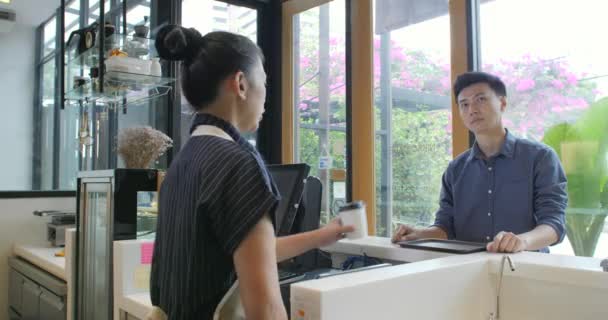 Vrolijke werknemer serveren een klant koffie te gaan — Stockvideo