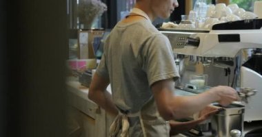 Barista iş başında. Kahve yapma süreci. Bir kahve dükkanında espresso bardak hazırlanıyor