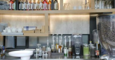 Gülümseyen ve bir fincan kahve sunan bir genç barista adam