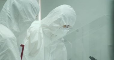 Takım güvenli yüksek düzey araştırma laboratuarında çalışan bilim adamı.