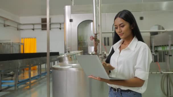 一个女工程师的肖像手持笔记本电脑看着饮料制造业的镜头. — 图库视频影像