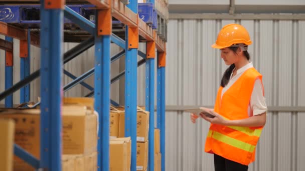 Young woman engineer using digital tablet checking stock in industrial warehouse — Stock Video