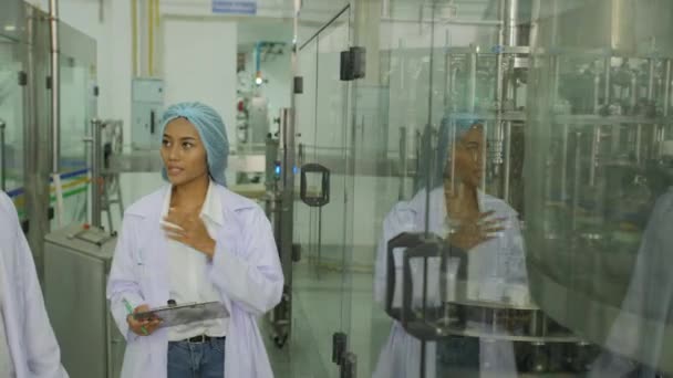 Dos ingenieros en proceso de producción de control uniforme blanco en una fábrica . — Vídeos de Stock