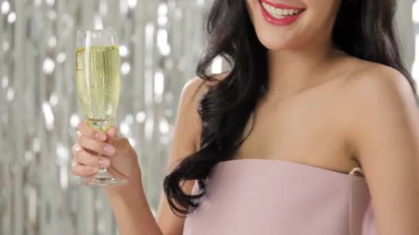 Hermosa mujer asiática sosteniendo copa de champán bailando entre confeti . — Vídeo de stock