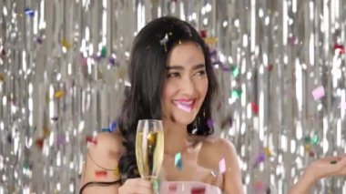 Konfeti arasında dans şampanya tutan güzel Asyalı kadın.