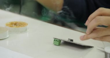 Asya elektronik mühendisi bir elektrik panosu onun atölyesinde lehimleme.