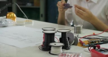 Kadın elektronik mühendisi onun atölyesinde bir elektrik panosu lehimleme.