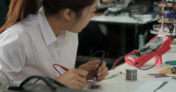 Mulher engenheiro eletrônico está medindo o sinal no circuito elétrico em sua oficina . — Vídeo de Stock