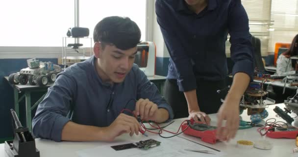 Estudante asiático está estudando eletrônica e medindo o sinal em sala de aula . — Vídeo de Stock