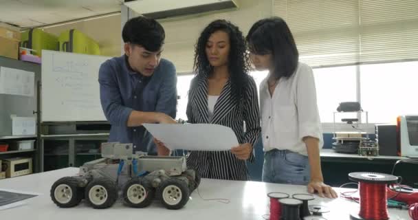 Equipe d'ingénieurs en électronique travaillant ensemble, collaborant sur un projet de construction de robot . — Video