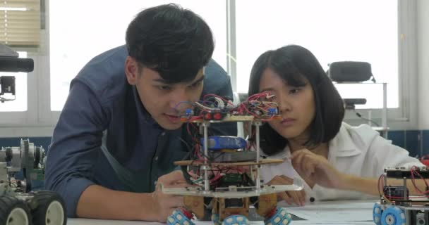 Equipo de ingenieros electrónicos trabajando juntos, colaborando en un proyecto para construir robots . — Vídeos de Stock