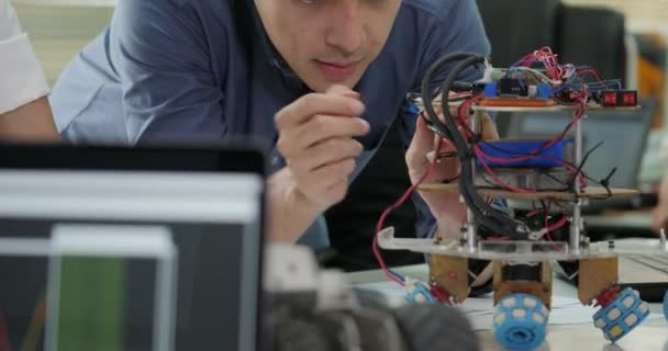 Equipo de ingenieros electrónicos trabajando juntos, colaborando en un proyecto para construir robots . — Vídeos de Stock