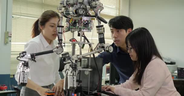 Equipo de ingenieros robóticos ensamblando y probando respuestas robóticas con computadora portátil . — Vídeos de Stock