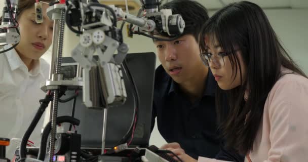 Équipe d'ingénieurs en robotique assemblant et testant les réponses robotiques avec un ordinateur portable . — Video