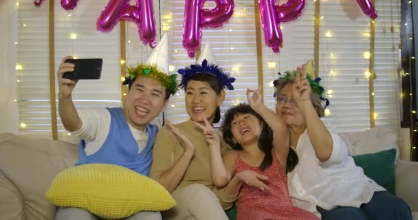 Porträtt av ung asiatisk familj avslappnande och tar selfie foto på soffan hemma. — Stockvideo